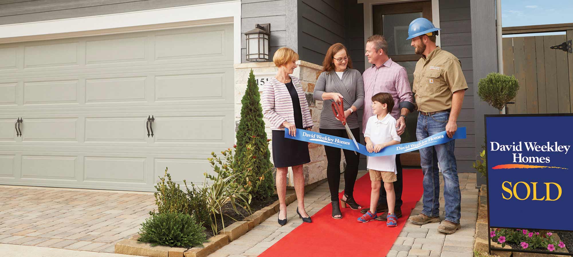 A David Weekley Homes Sales Consultant and Personal Builder welcome a family to their new home