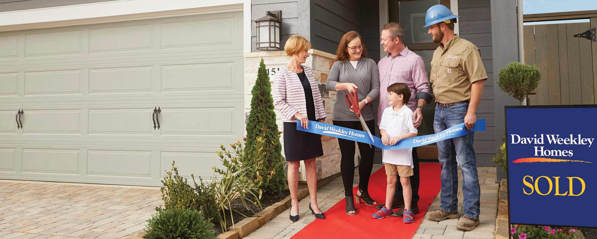 A David Weekley Homes Sales Consultant and Person Builder welcoming a family to their new home